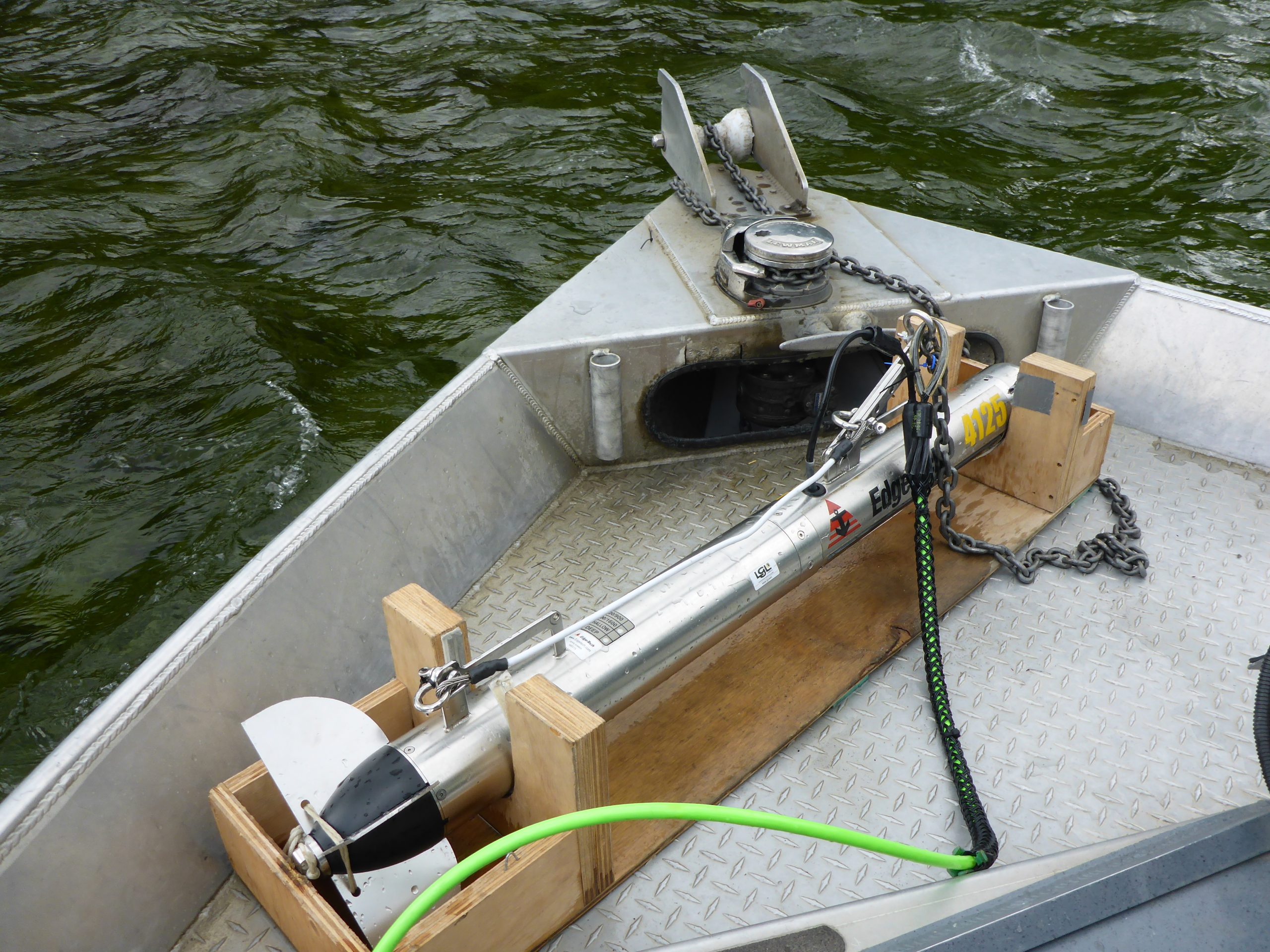 A large piece of equipment, called a side scan sonar towfish, setup on the stern of a survey boat. 